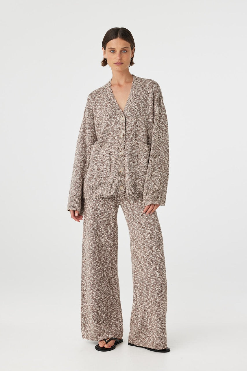 Emmet cardigan in chocolate and cream worn at an angle, highlighting the button front detail, wide sleeves and soft slub knit texture, styled with brown pants and sandals