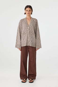 Emmet cardigan in chocolate and cream worn front on, showcasing the longline relaxed fit, textured slub knit and centre front button closure, styled with matching knit pants and sandals