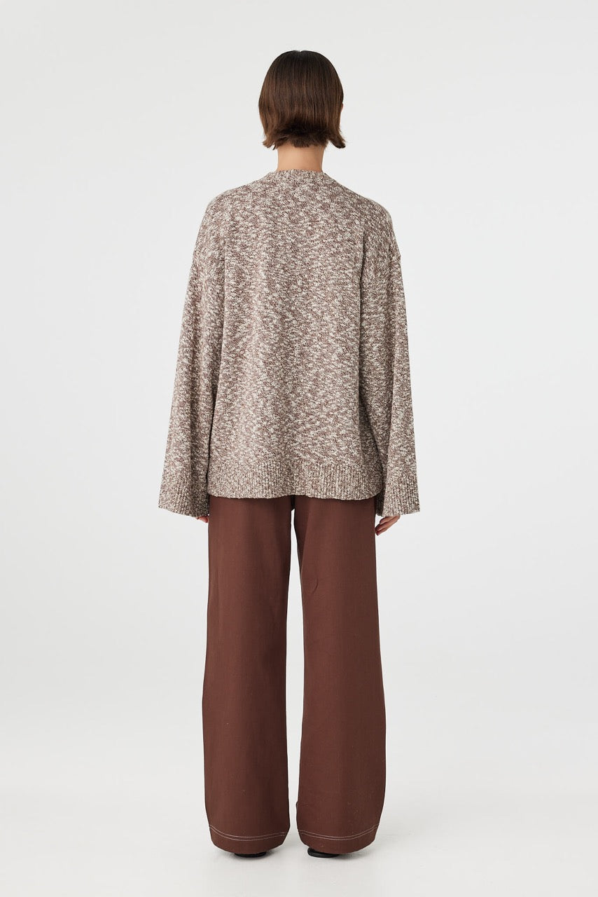 Emmet cardigan in chocolate and cream viewed from back, showing the clean longline shape and subtle texture throughout, styled with brown pants and sandals