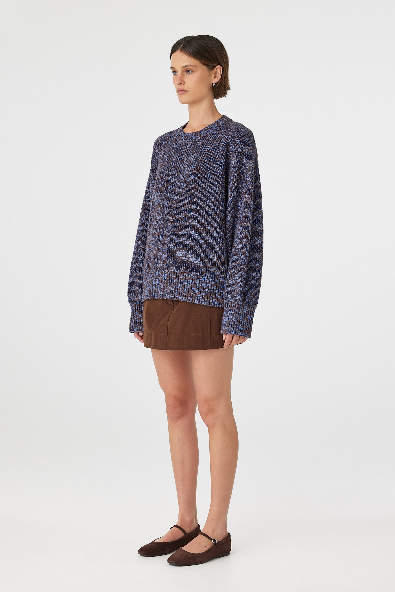 Eames mini skirt in espresso styled with a knit sweater in side profile, highlighting the clean lines and structured shape