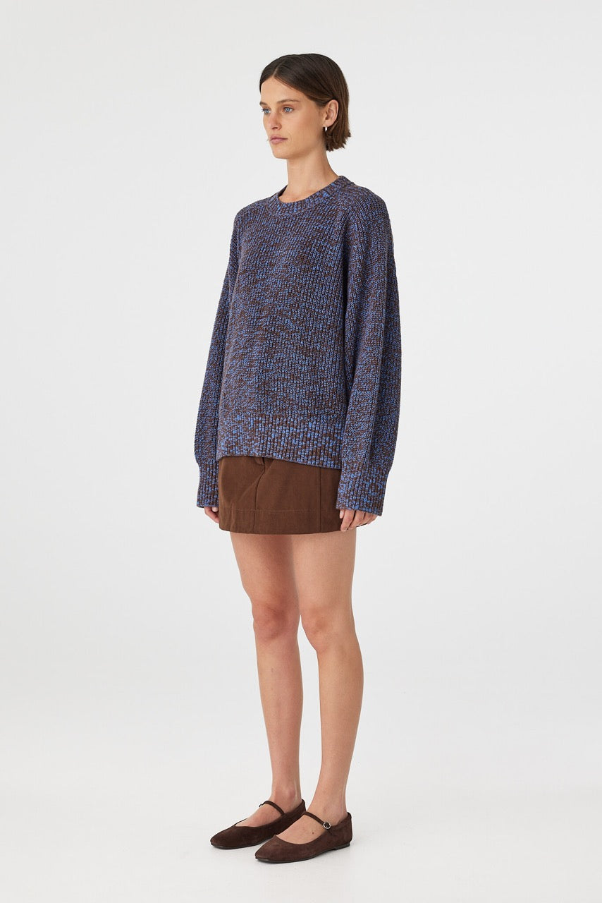 Eames mini skirt in espresso styled with a knit sweater in side profile, highlighting the clean lines and structured shape