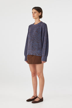 Solene sweater in chocolate and royal blue mottled knit shown in side profile, highlighting the relaxed oversized silhouette, long raglan sleeves and textured cotton knit