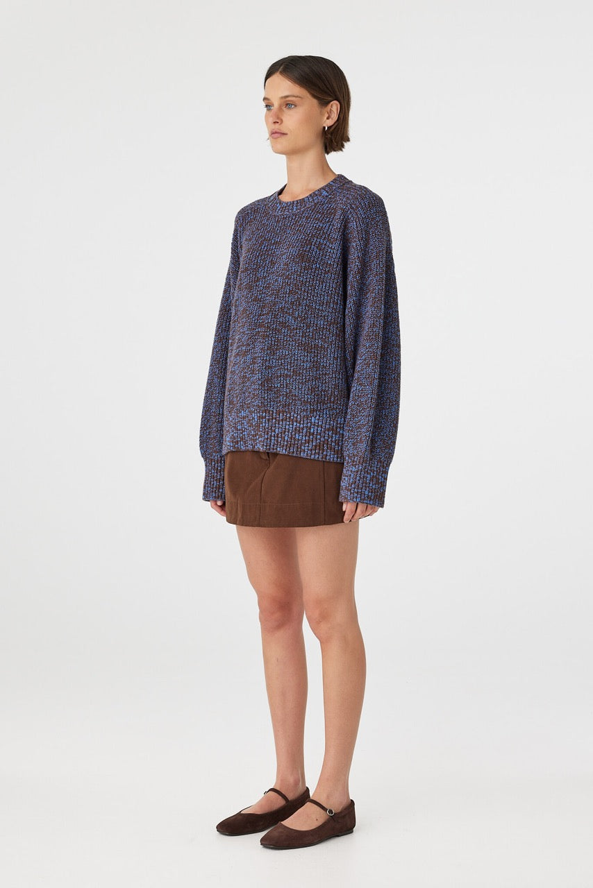 Solene sweater in chocolate and royal blue mottled knit shown in side profile, highlighting the relaxed oversized silhouette, long raglan sleeves and textured cotton knit