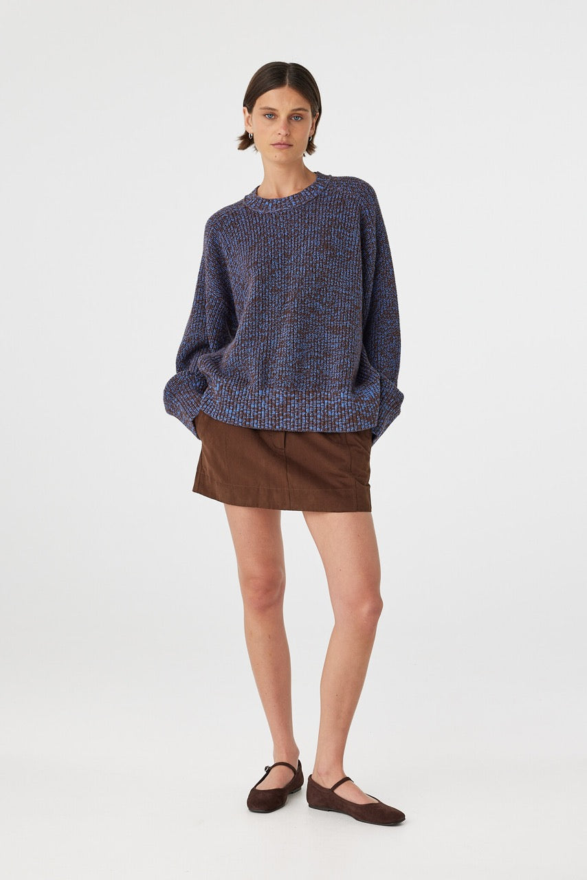 Solene sweater in chocolate and royal blue worn slightly angled, highlighting the chunky knit texture, ribbed cuffs and oversized drape through the body