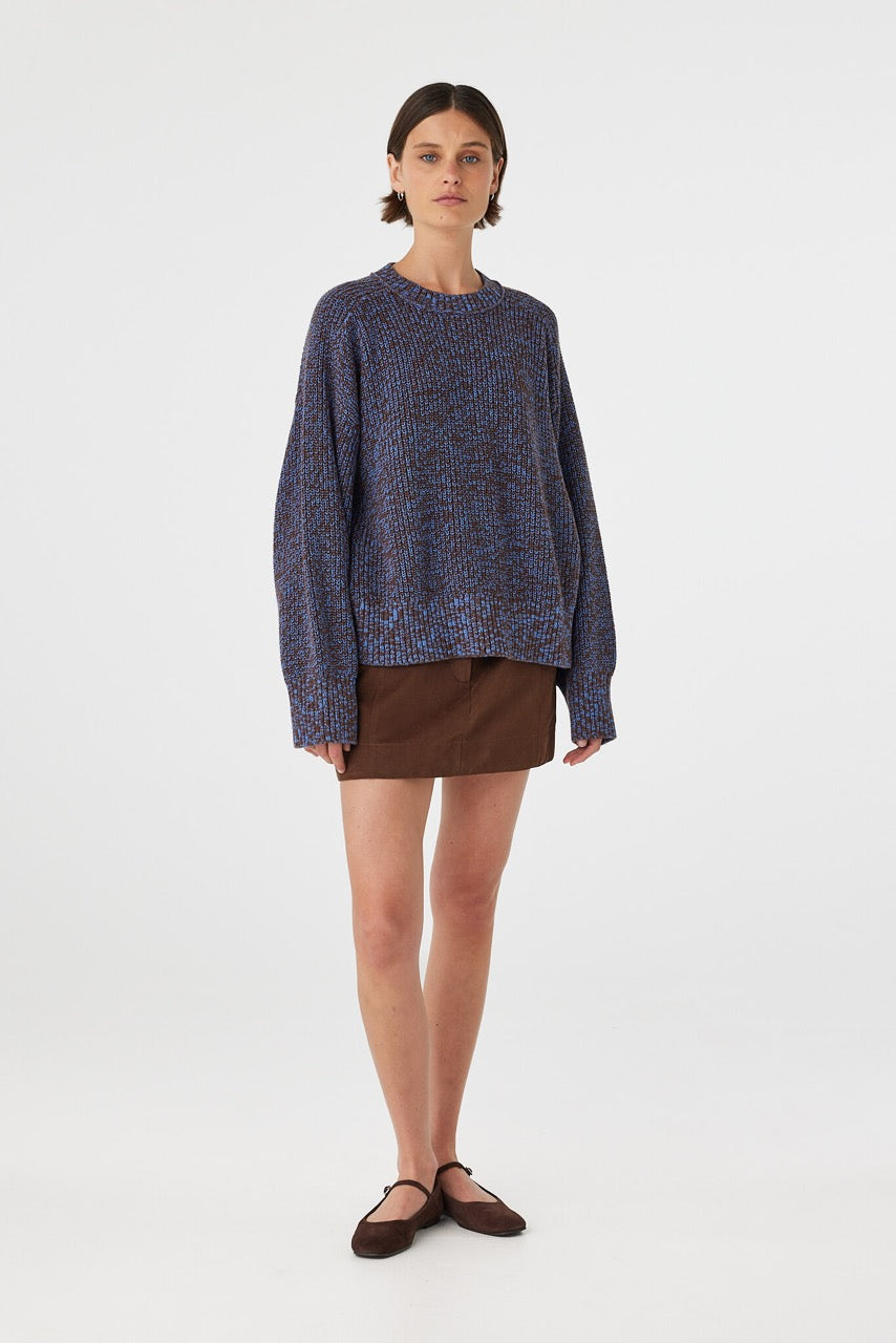 Solene sweater in chocolate and royal blue knit styled with a brown mini skirt, showcasing the relaxed fit, dropped shoulders and soft structured cotton texture