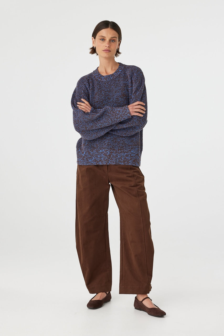 Solene sweater in chocolate and royal blue worn slightly angled, highlighting the chunky knit texture, ribbed cuffs and oversized drape through the body