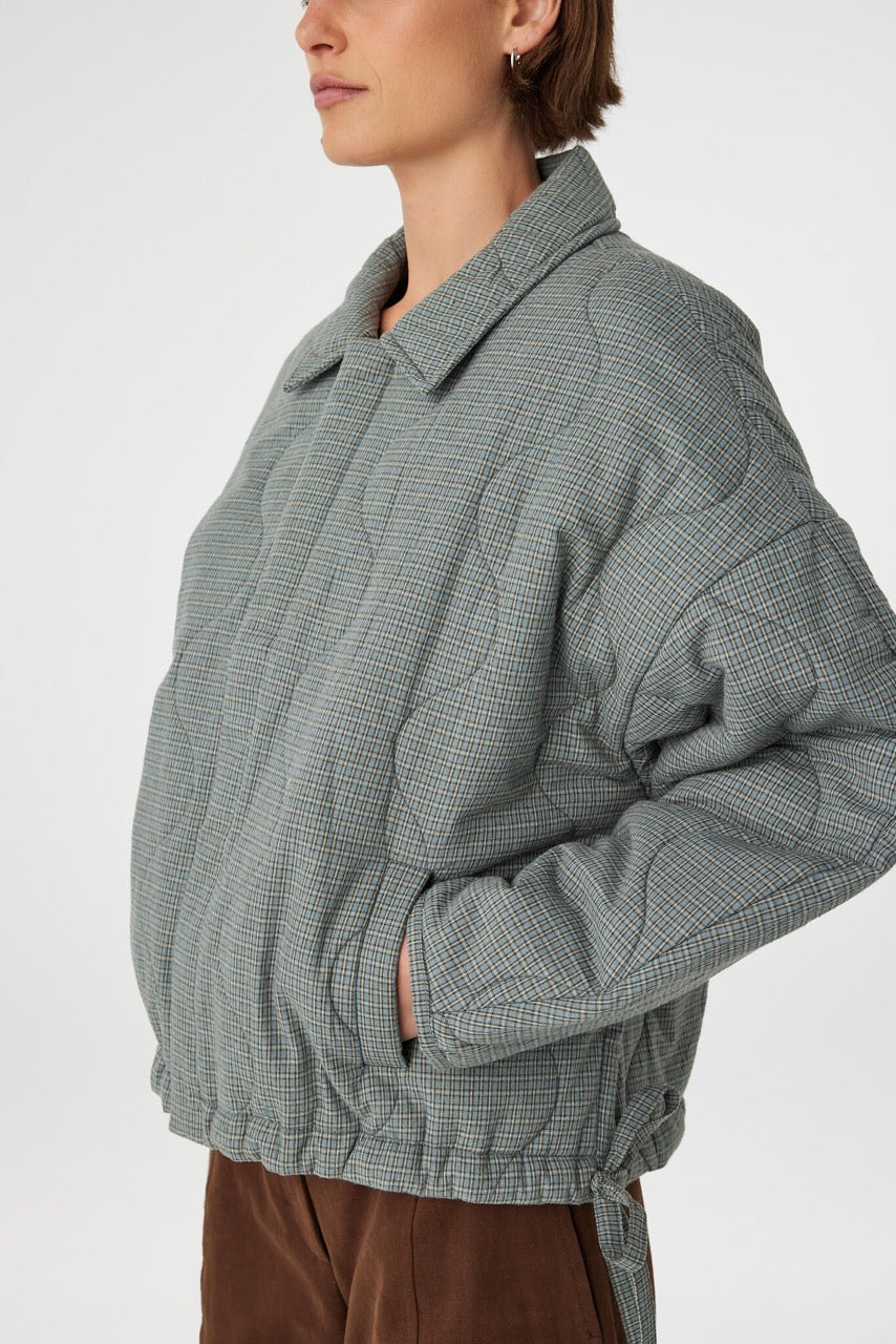 Side view Close detail of Matteo Jacket blue check, quilted cotton texture with drawstring hem tie.