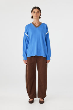 Eden long sleeve tee in royal blue and espresso worn front on, featuring an oversized slouchy fit, ribbed V-neckline and contrast shoulder detailing, styled with brown trousers