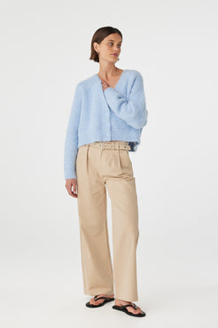 Liora fluffy cardigan in sky worn front on, highlighting the cropped length, ribbed cuffs and hem, and relaxed fit, styled with beige trousers and black sandals