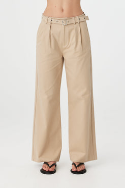 Soraya Pant taupe angled front view showing pleat detail and wide leg silhouette with eyelet belt styled with black fitted top