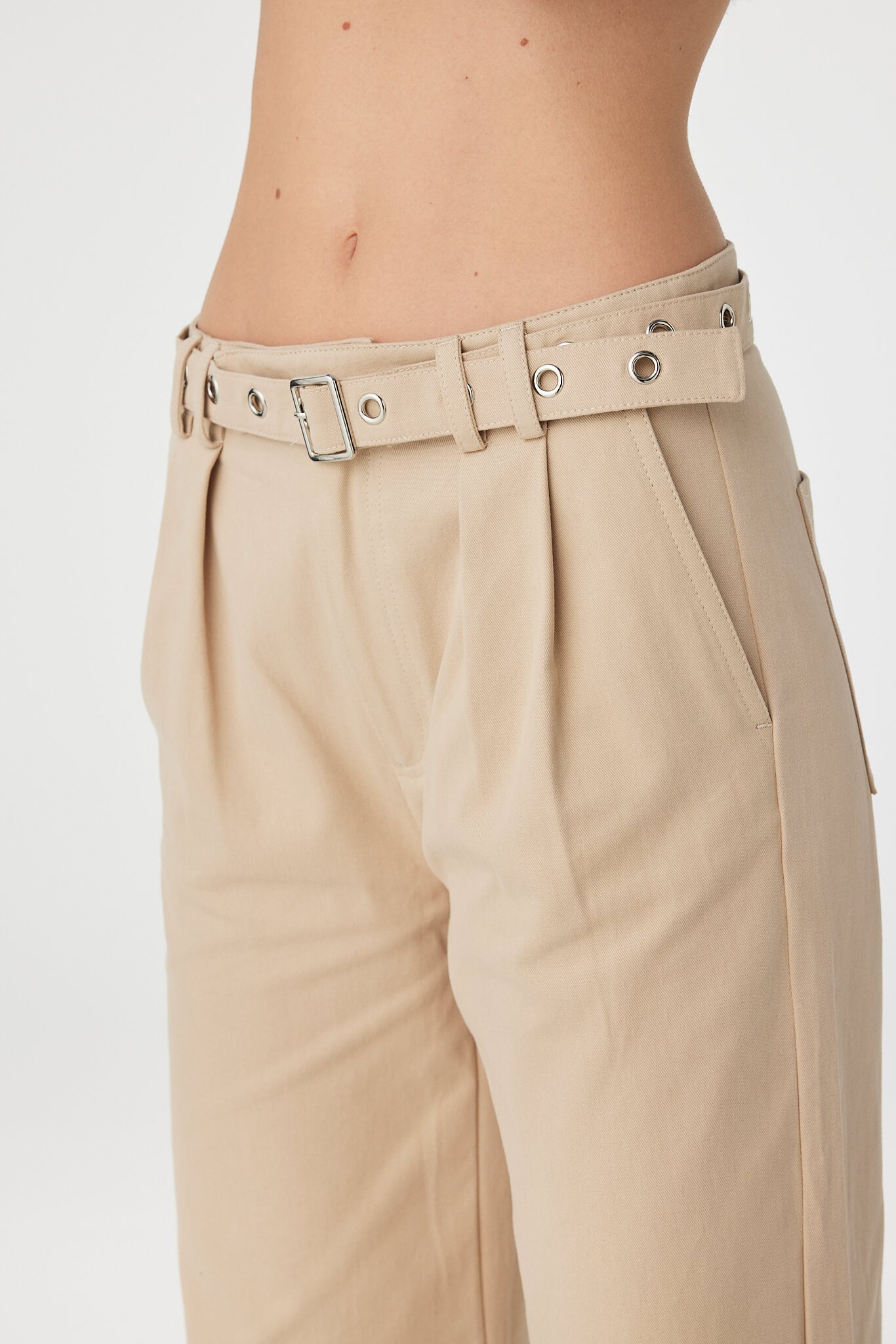 Soraya Pant taupe close up of waistband featuring belt loops, metal eyelet belt and pleated front detail