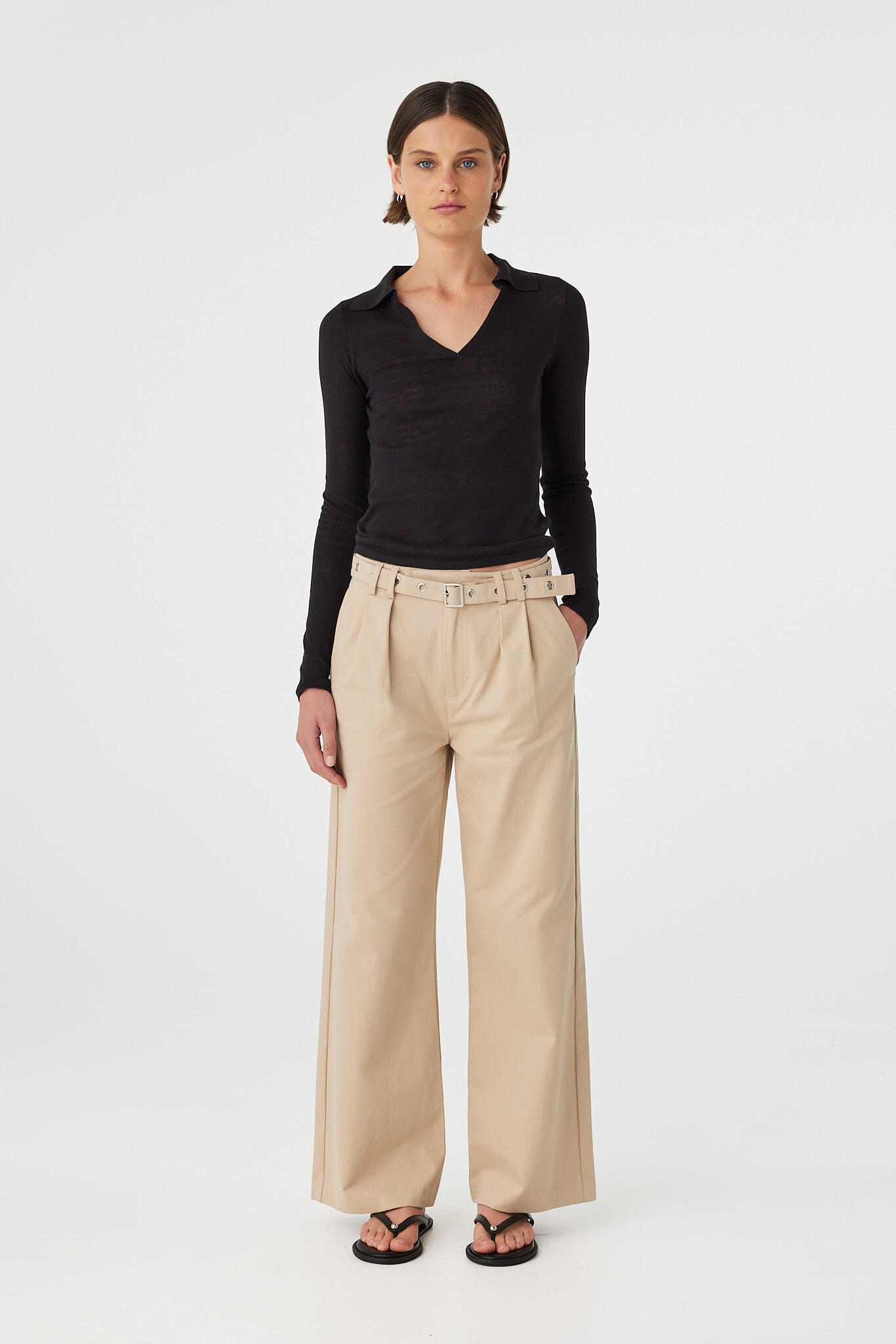 Mae long sleeve top in black worn front on, showing the soft drape, V neckline and collar detail, styled with taupe wide-leg pants and sandals
