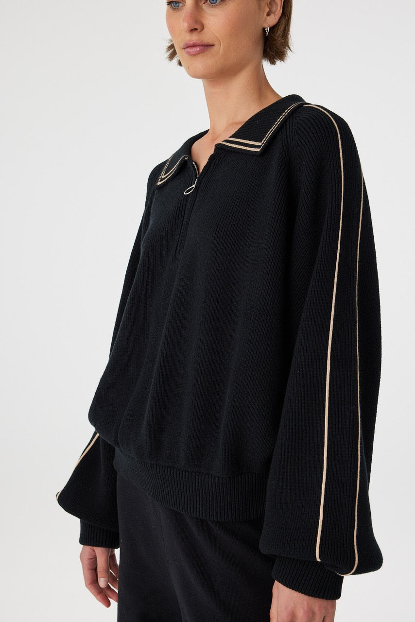 Nella zip sweater in black and taupe close-up detail, showcasing the ribbed knit texture, contrast piping and metal zip at the neckline