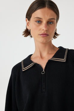 Nella zip sweater in black and taupe close-up detail, showcasing the ribbed knit texture, contrast piping and metal zip at the neckline