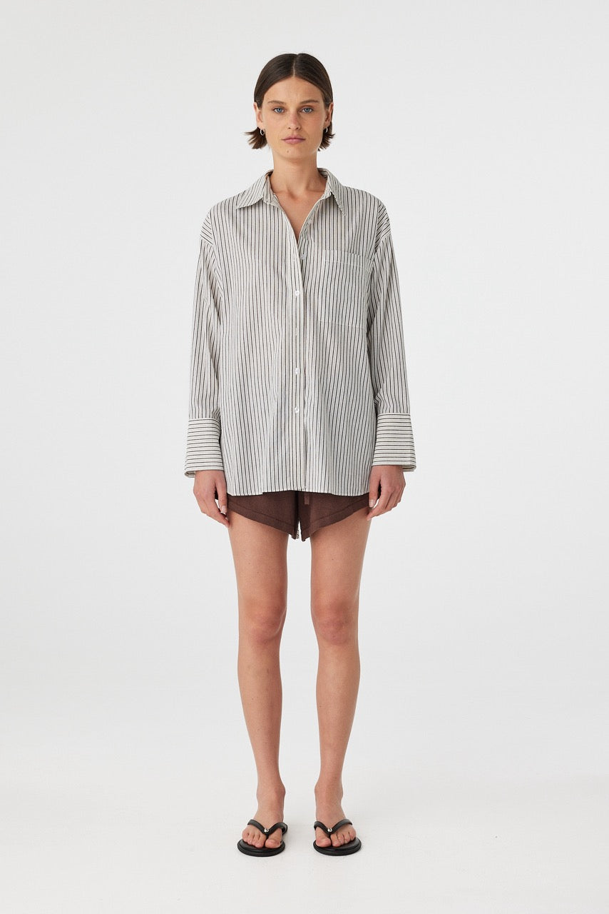 Front view of model wearing black and white striped oversized cotton boyfriend shirt with shorts