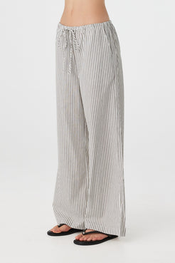 Side profile of woman in black and white striped straight-leg pants