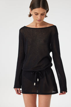 Sheer black cotton long sleeve mini dress with a loose fit and boat neckline, lightweight knit designed for layering over swimwear in warm coastal climates.