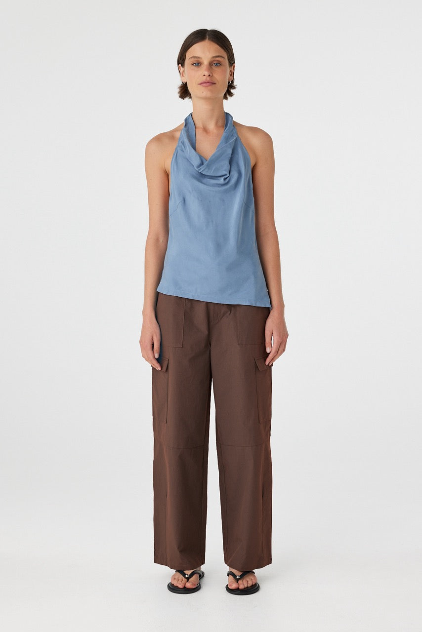 Full body front view of model wearing teal blue halter top with brown cargo pants 