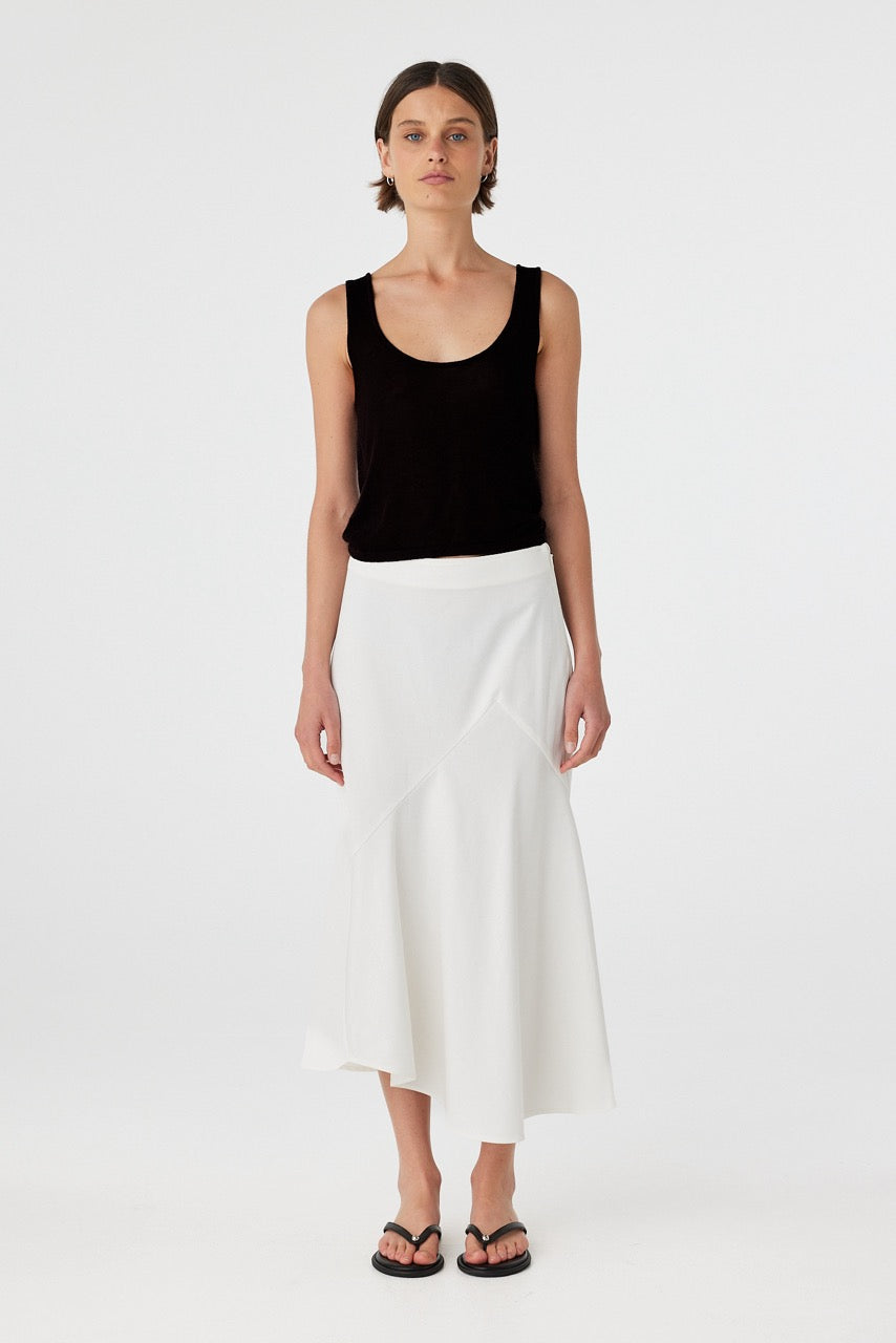Model in black cotton knit tank top paired with white pants, showing relaxed fit and low-back silhouette.
