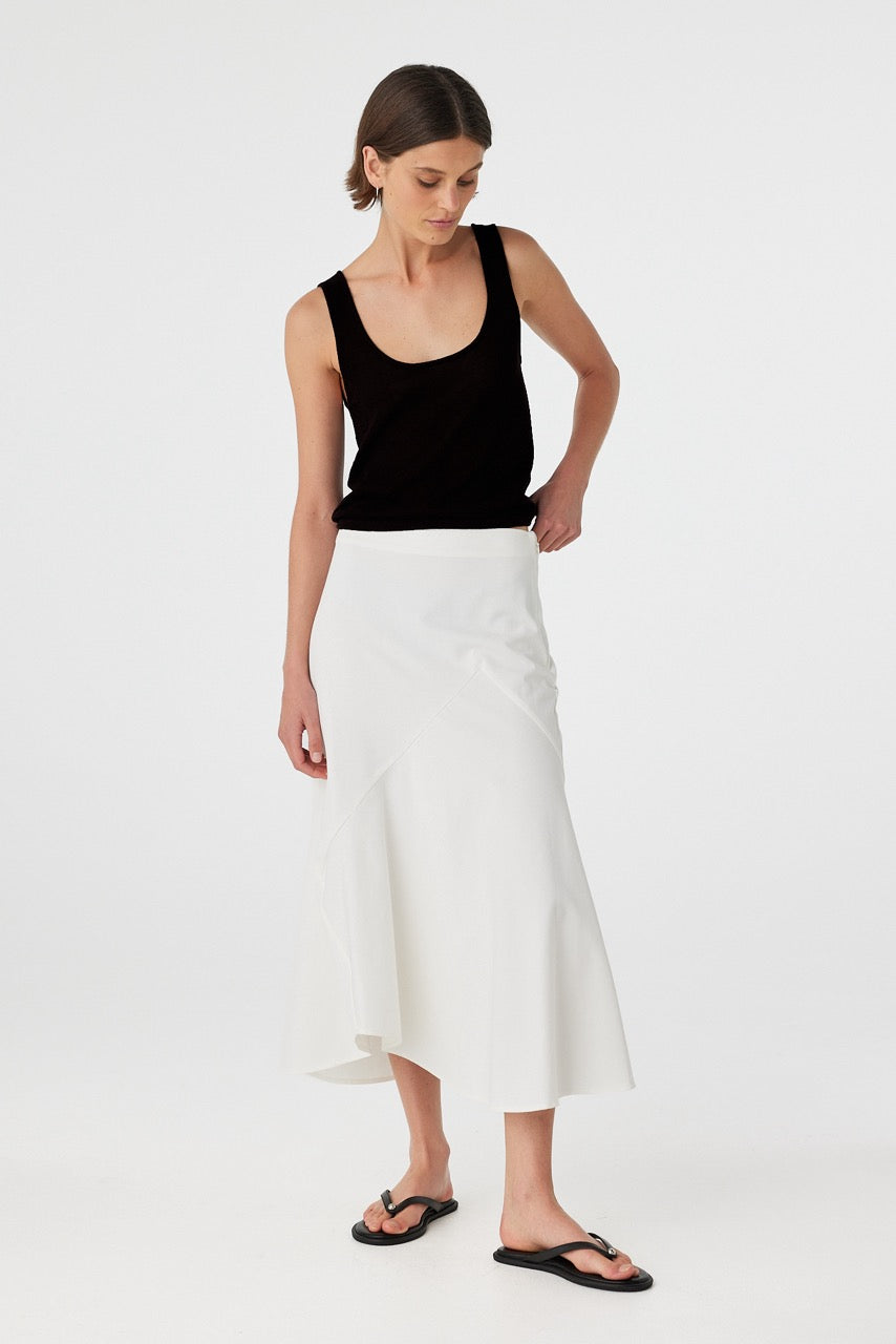 Full-body angled shot of black semi-sheer cotton tank top styled with an asymmetrical white skirt,