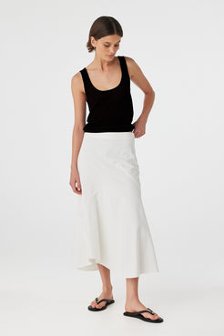 Full-body angled shot of black semi-sheer cotton tank top styled with an asymmetrical white skirt,