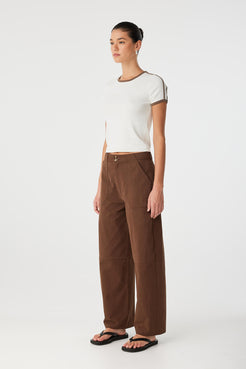 Side profile of model wearing chocolate pants and tee, illustrating shape and comfort in movement.
