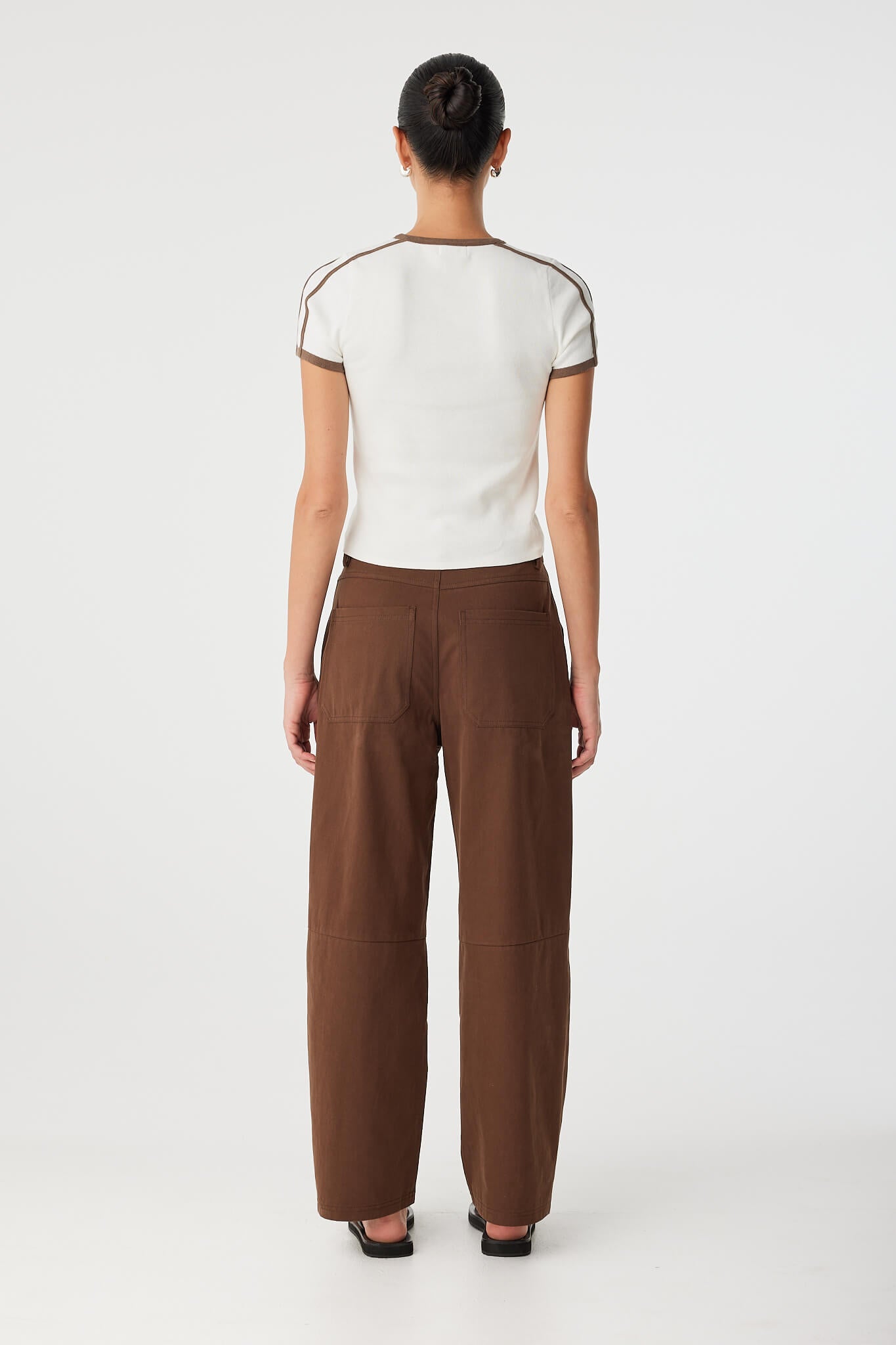 Back view of cotton pant worn with white tee, showing soft taper and waist detail.