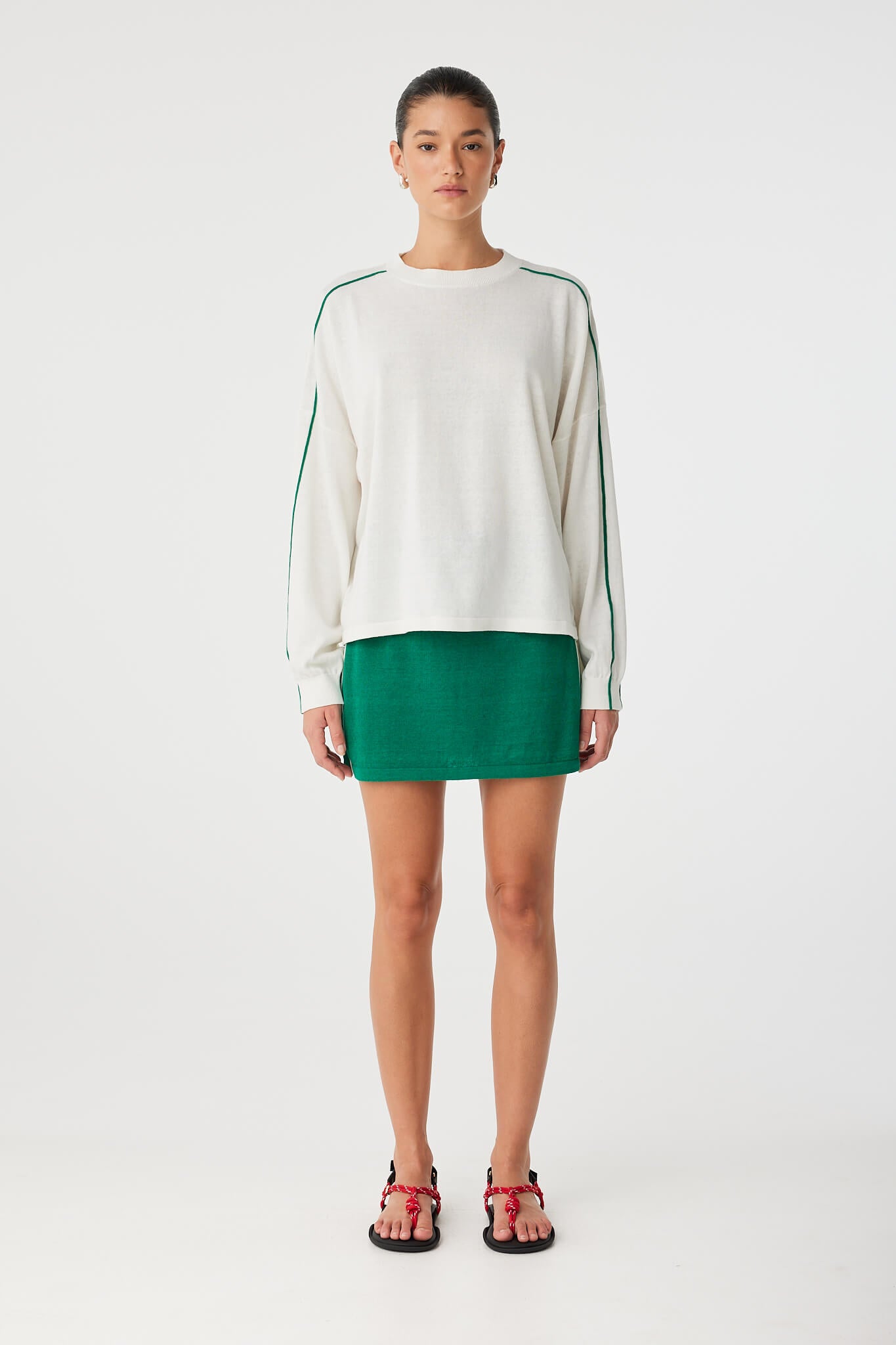 Pippa Mini Skirt styled with oversized knit top, showing sporty contrast stripe detail.