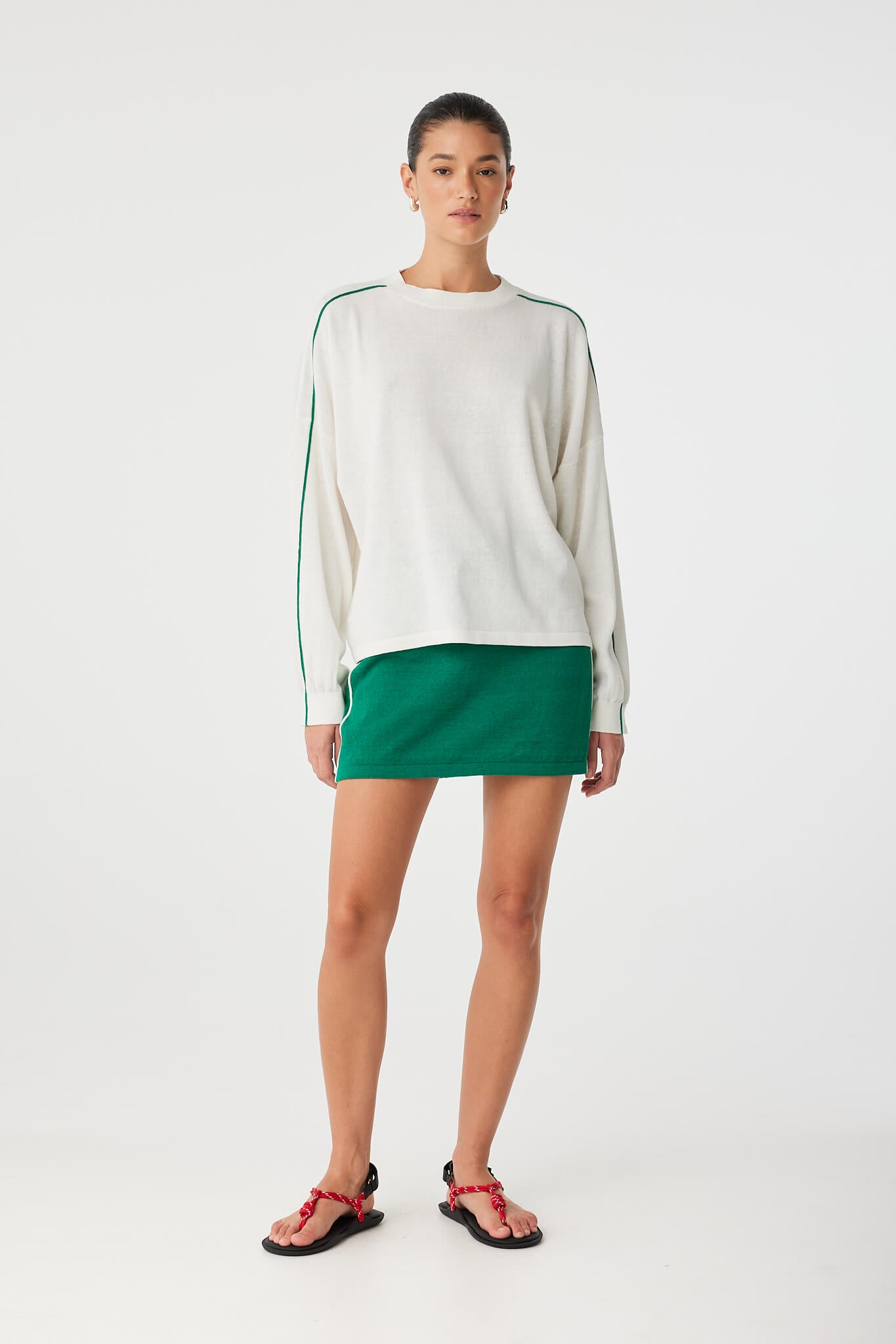 Model wearing long sleeve tee and green skirt, showing relaxed movement and fit.