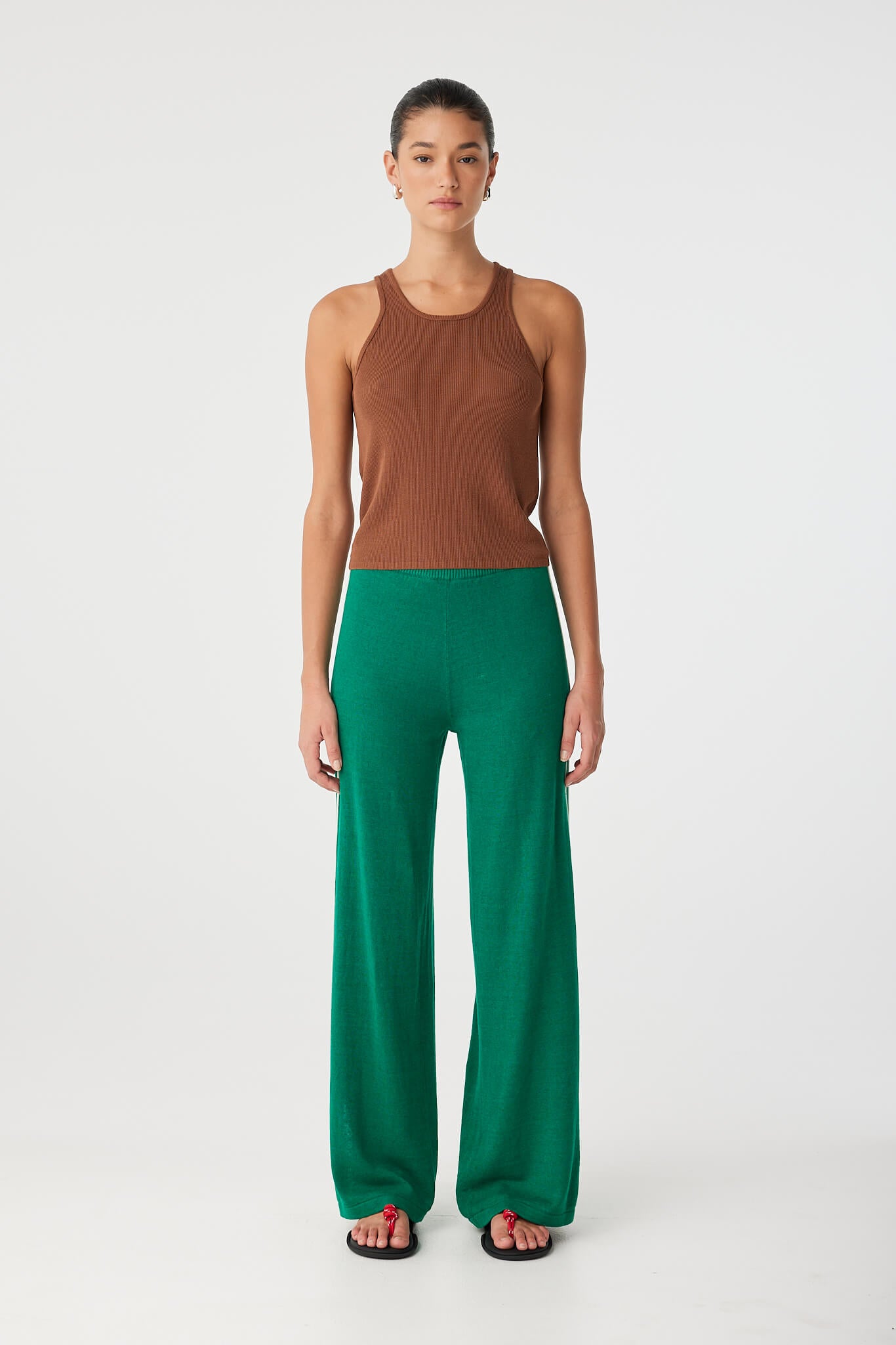Rio Tank styled with green wide-leg pants, showcasing close fit and athletic neckline.