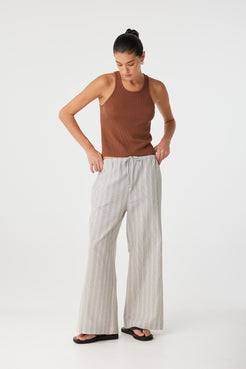 Model with hands on hips wearing clay stripe pant styled for elevated casual dressing.