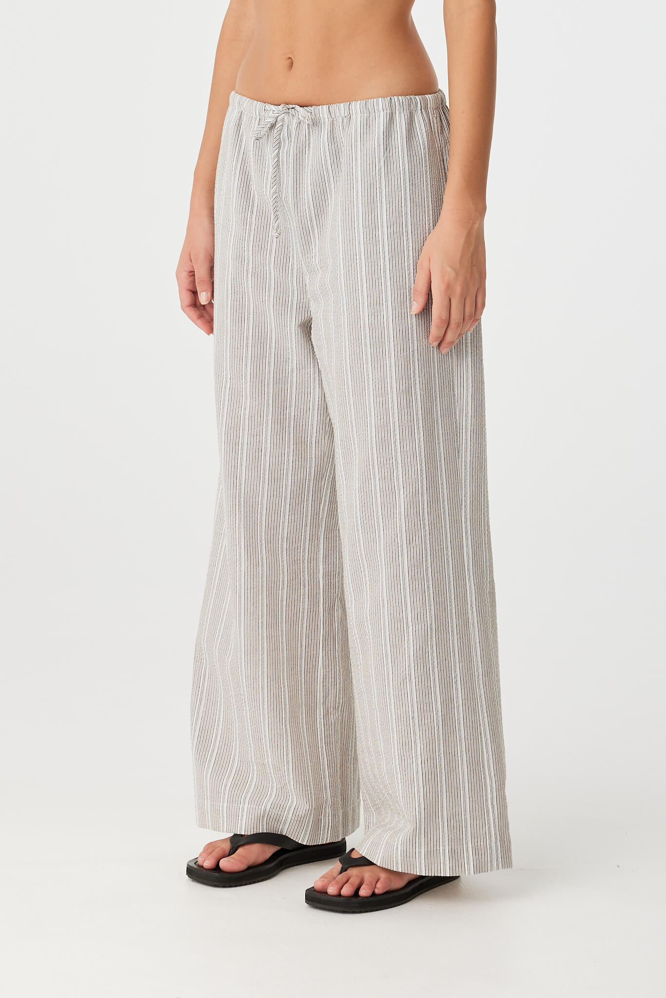 Side view of pants highlighting wide leg shape and textural stripe detail.