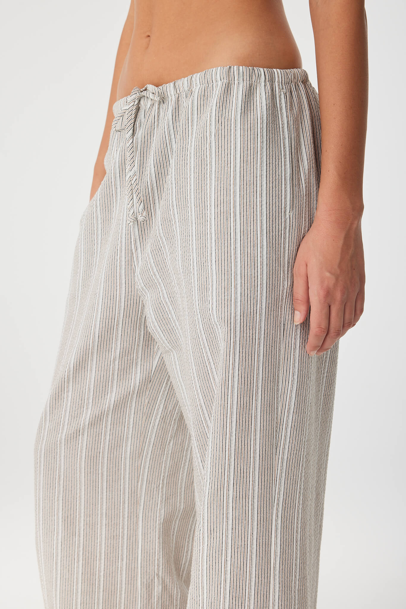 Close-up of drawstring waist and side seam pocket in lightweight striped cotton.