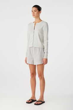 Profile shot featuring cropped hem and clean silhouette of the cardigan.