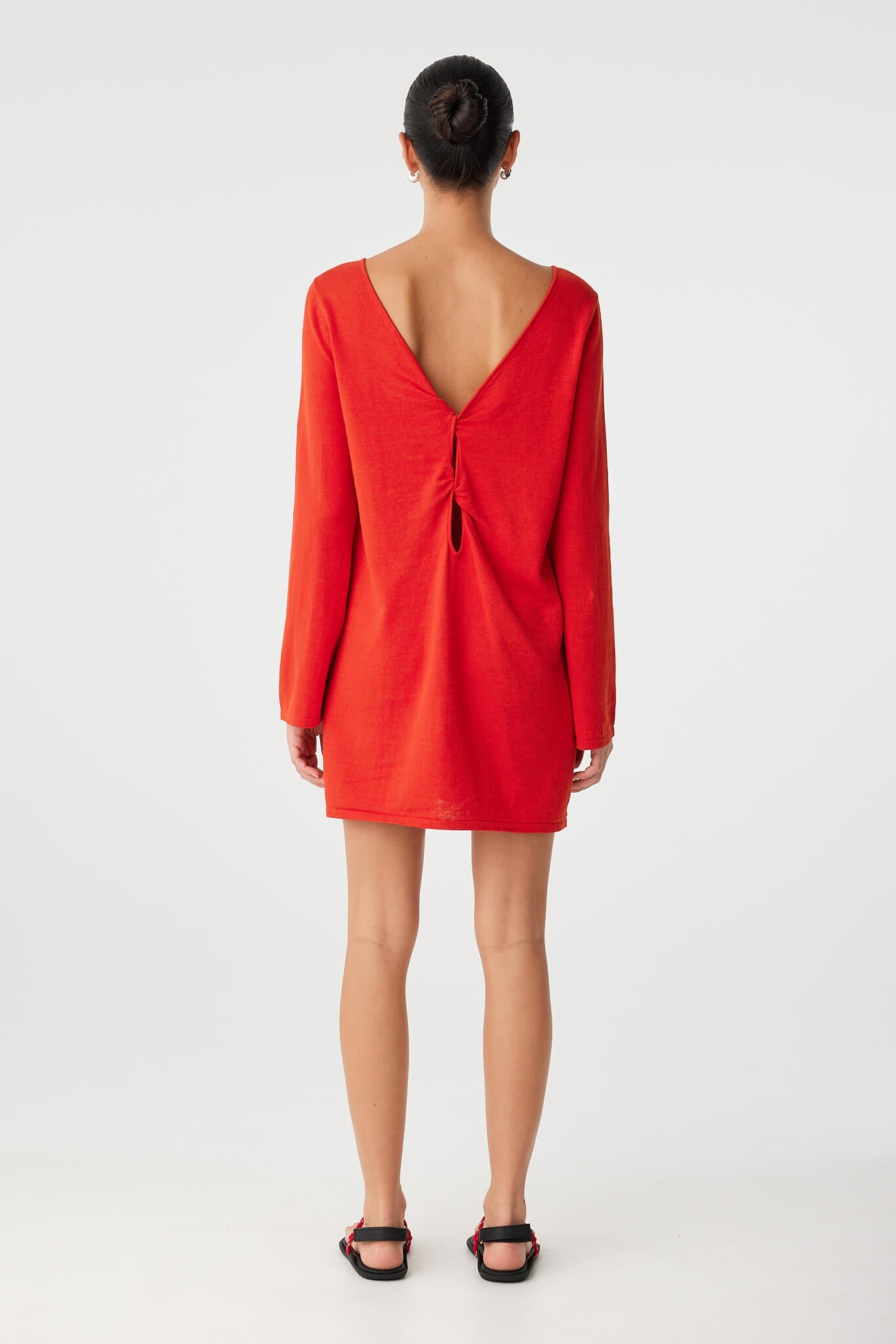 Back view of twist cut-out worn at back, showcasing the reversible design and elegant drape of textured natural fabric.