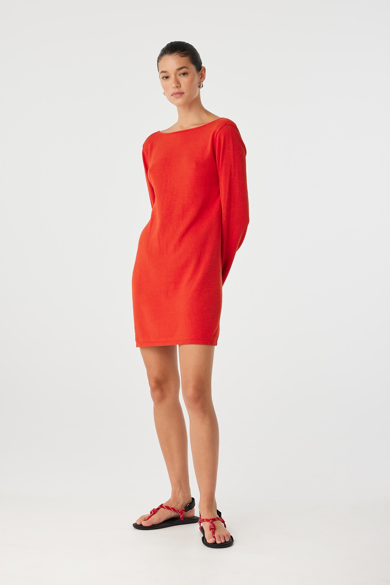 Model in cherry red mini dress with long sleeves and rounded neckline, made in a soft linen–cotton blend for everyday wearability.