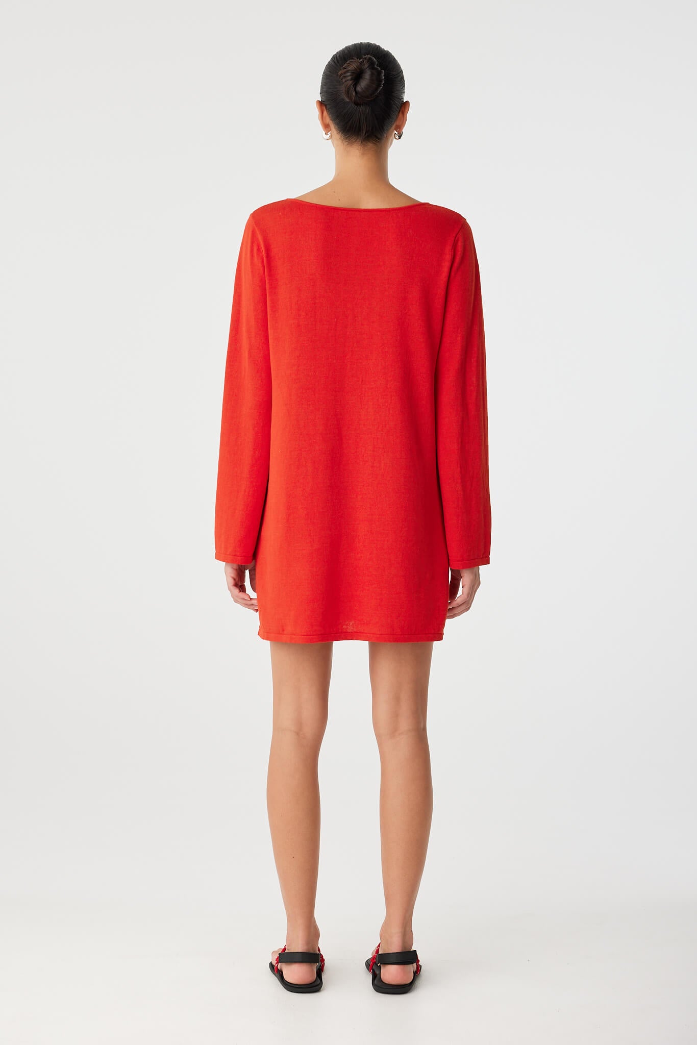 Full back view of long sleeve shift dress with smooth finish and high neckline, styled for minimal occasion wear.