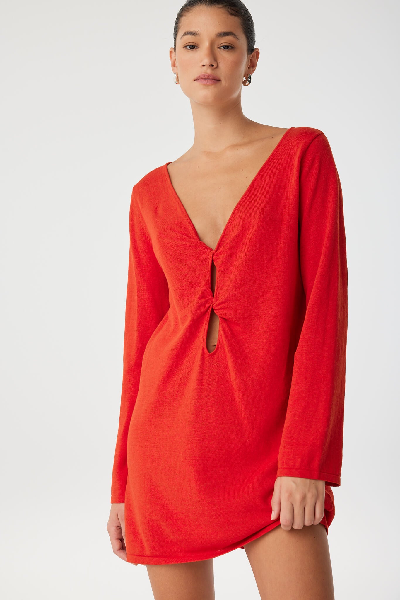 Twist-front reversible shift dress in bright red, styled with sandals—crafted for movement and transitional ease.