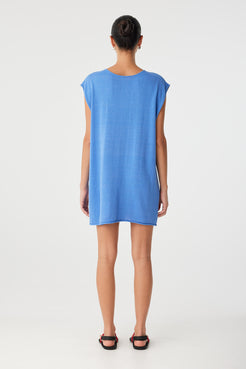 Back view of the Pala Dress worn with high neckline and smooth back, showing clean shift silhouette in breathable pacific blue linen–cotton blend.