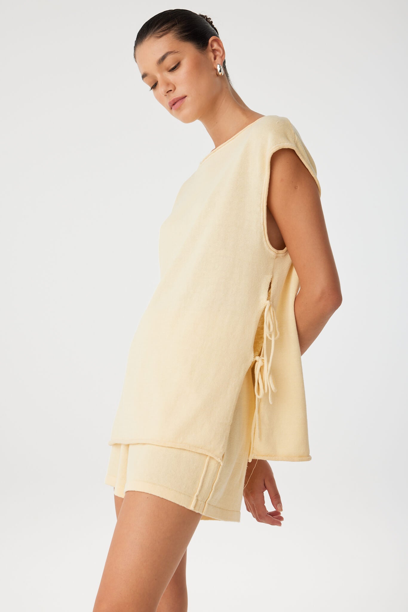 Side view of open-split linen blend top with rolled edge and adjustable tie.