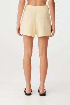 Back view of relaxed-fit shorts in lightweight linen–cotton, styled simply for summer.
