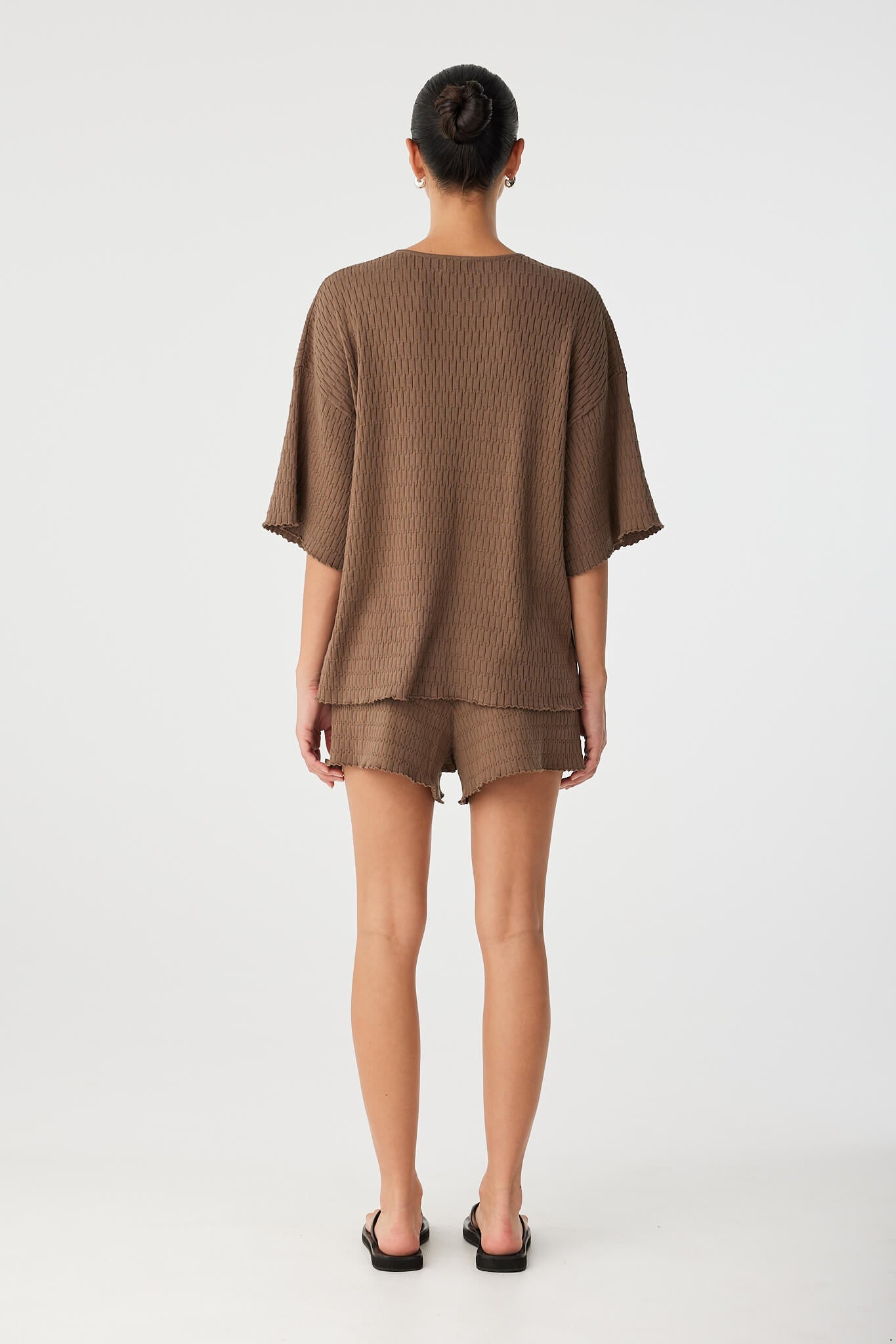 Back view of oversized organic cotton tee with dropped shoulder seam and straight hemline.