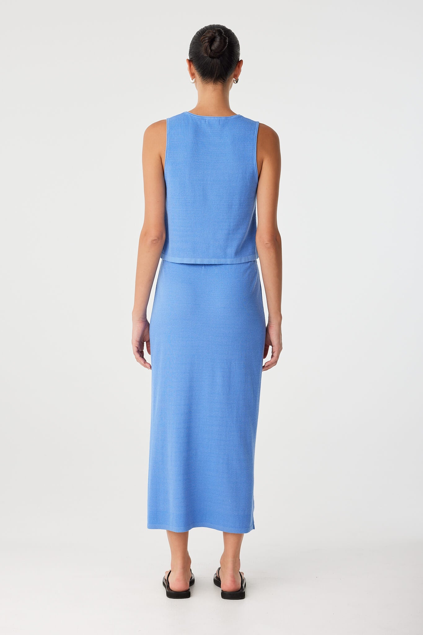 Back view of ribbed knit skirt in lightweight blue cotton–hemp, worn high-waisted with subtle stretch and minimal seaming.
