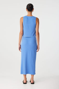 Back view of ribbed knit skirt in lightweight blue cotton–hemp, worn high-waisted with subtle stretch and minimal seaming.