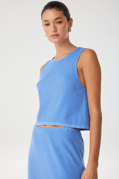 Model in soft cotton–hemp knit tank styled with coordinating skirt for minimal warm-weather dressing.