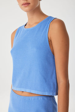 Close-up of ribbed knit hem and rolled finish on lightweight tank in pacific blue—crafted for breathable comfort.