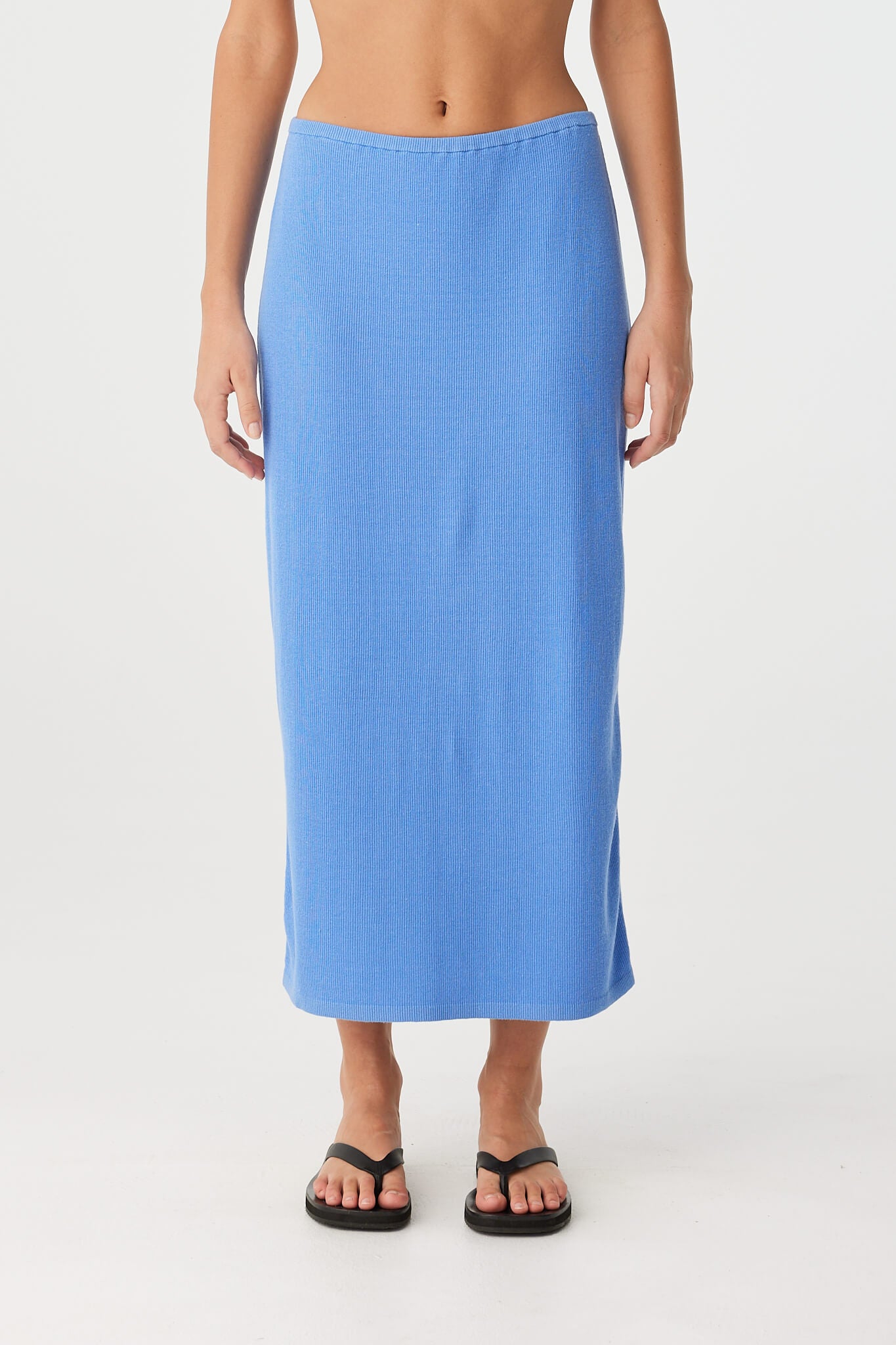 Longline knit skirt in soft blue with slim silhouette and natural drape—ideal for everyday warm-weather dressing.