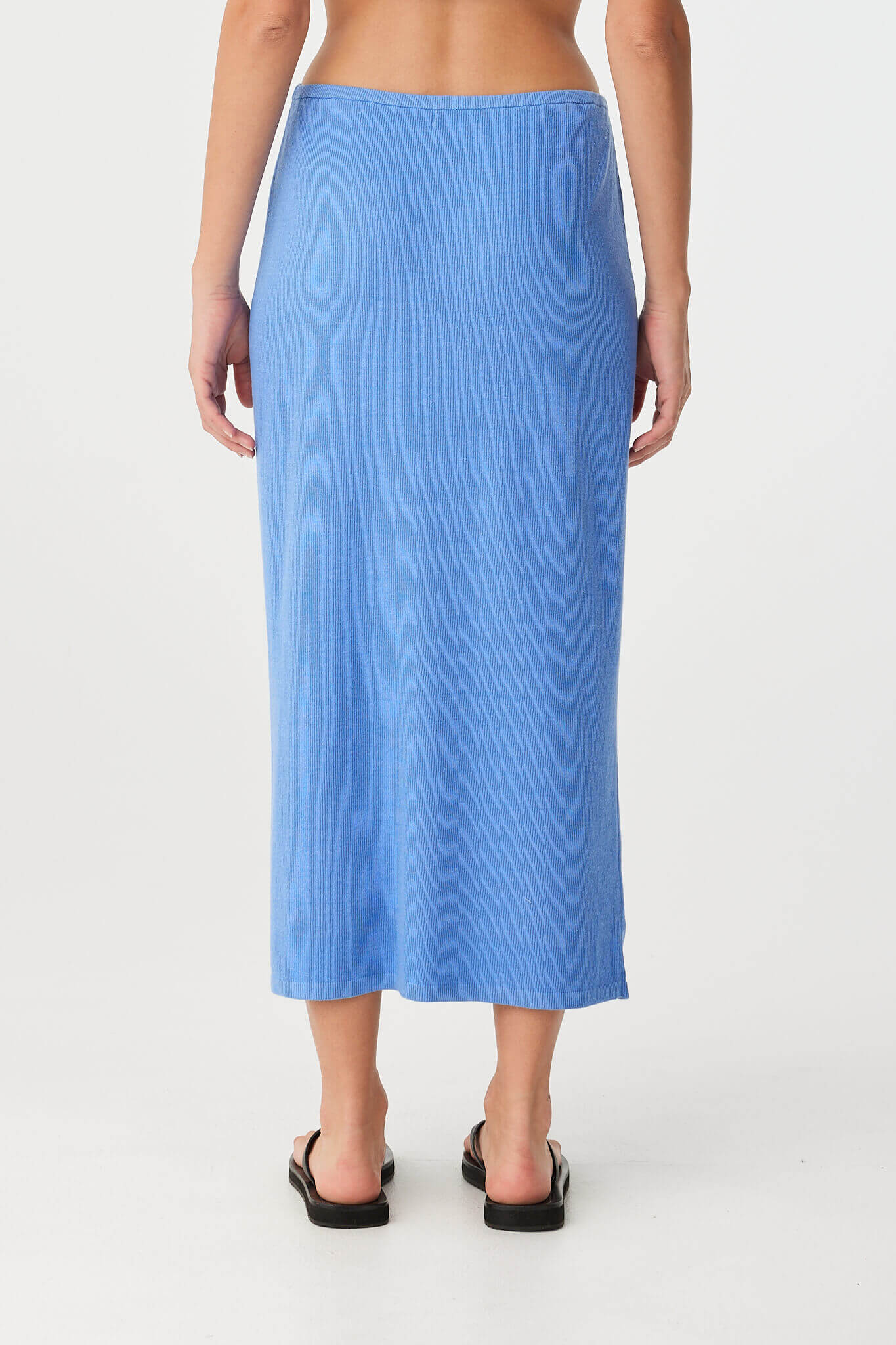 Back view of the Theo Skirt worn high-waisted, showing soft ribbed texture and fluid drape in lightweight pacific blue cotton–hemp knit.