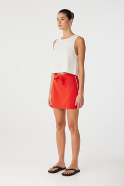 Side angle of mini skirt in linen–cotton blend with contrast detailing and relaxed fit through hip.