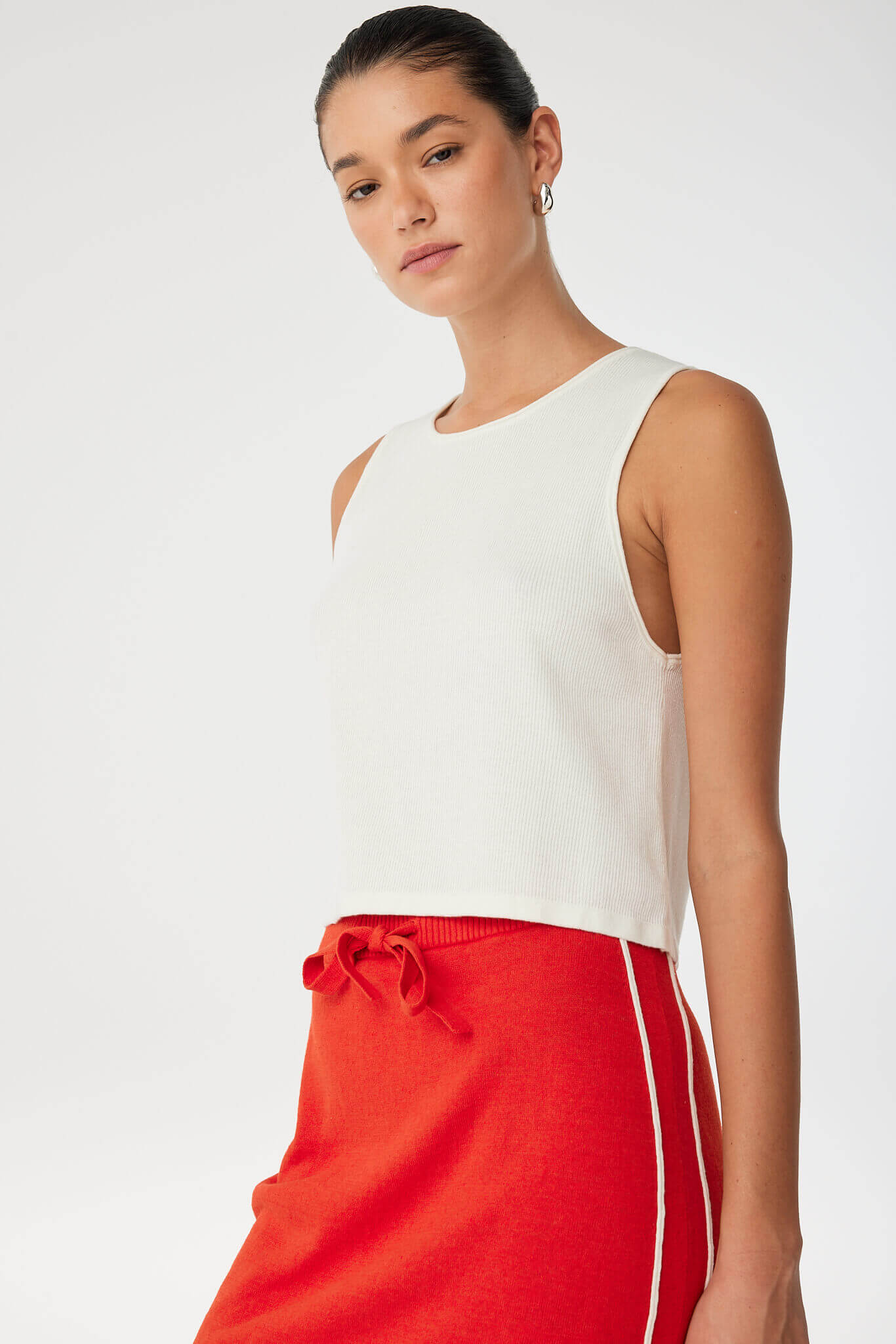 Side view of Theo Tank showing soft texture, wide armholes and gentle drape in breathable cream knit.